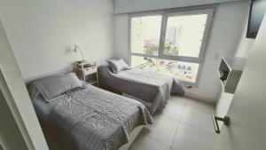 a small room with two beds and a window at LUX TOWER Punta del Este Port in Punta del Este +33 photos