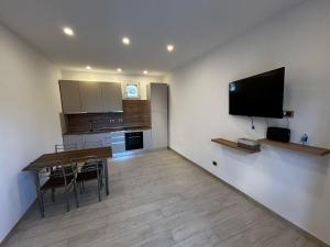 a kitchen with a dining table and a flat screen tv at Casa De Grazia in Tarquinia