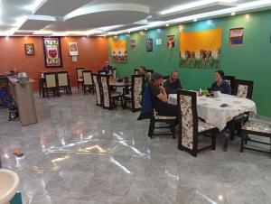 a group of people sitting at tables in a restaurant at JC ITEN Guest House in Iten