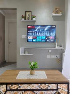 a living room with a tv on a wall at Appartement Cosy calme et climatisé avec WIFI Rapide in Boumhel El Bassatine