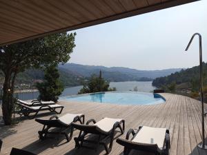 a deck with chairs and a swimming pool with a view at Casa do Gerês 2021 in Geres