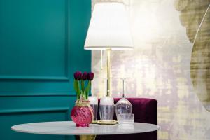 a table with two vases and a lamp on it at Sokak Heritage Apartments in Bitola