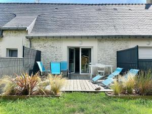 a patio with blue chairs and a table in front of a house at Maison calme avec jardin privé, 4 couchages, proche de La Baule - FR-1-245-176 in Saint-André-des-Eaux