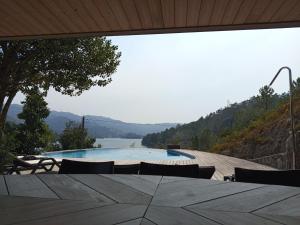 a view of a swimming pool with a table and chairs at Casa do Gerês 2021 in Geres