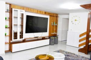 a living room with a large television on a wall at Cosy by dalyda in Yaoundé