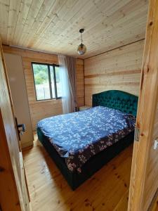 a bedroom with a bed in a wooden room at Qusarion - ქუსარიონი in Agara