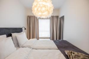 a bedroom with a large bed and a chandelier at Nordic Dream - best location with Sauna in Rovaniemi