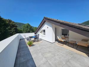 a patio with chairs and tables on a roof at Ferienwohnung *Am Bronnwiesle* in Deggingen