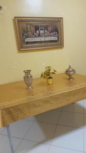 a wooden table with two vases and a picture on the wall at Casa da iluminada in Belém