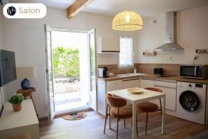 a kitchen with a table and chairs in a room at Le Verdon, cozy et authentique in Gréoux-les-Bains