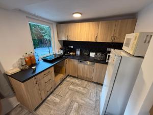 a kitchen with wooden cabinets and a white refrigerator at Jére Lak in Băile Homorod