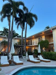 a hotel with palm trees and a swimming pool at La Casa Hotel in Fort Lauderdale