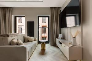 Una sala de estar con un sofá y dos ventanas. en Gdańsk Luxury Stay, en Gdansk