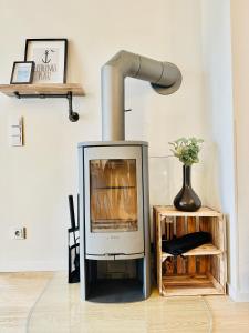 a fireplace in a living room with a lamp at Nordlicht, Olpenitz - moderne Ferienwohnung in direkter Strandnähe mit eigenem Eingang, Sauna, Kaminofen, Terrasse und Parkplatz in Olpenitz