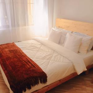a bed with white sheets and a brown blanket on it at SkyNest 2BR Modern Apt Unit in Soroti +7 photos