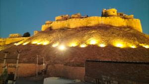 Un castillo en una colina con luces. en Hotel akty Jaisalmer, en Jaisalmer