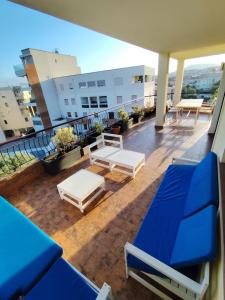 ein Balkon mit blauen Bänken und Tischen auf einem Gebäude in der Unterkunft Casa vacanze da Alice in Alghero
