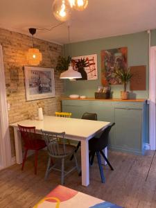 a dining room with a white table and chairs at Central Aalborg Cozy and Quiet in Aalborg
