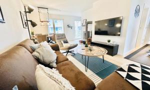 a living room with a couch and a table at Nordlicht, Olpenitz - moderne Ferienwohnung in direkter Strandnähe mit eigenem Eingang, Sauna, Kaminofen, Terrasse und Parkplatz in Olpenitz