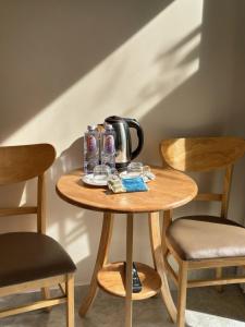 a table with a tea kettle and cups on it at Kha Phat Central Dalat with Local Charm in Xuan An