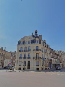 a large yellow building on the corner of a street at Le Brillant - Studio in Reims