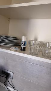 a kitchen counter with bowls and plates on a shelf at Residence Parco Castello 1 in Novi Ligure +9 photos