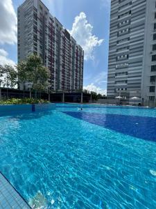 a swimming pool in front of two tall buildings at Cozy Condo Admiral Residences Melaka in Melaka