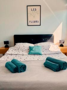 a bed with two green pillows on top of it at Apartament Wysockiego in Bielsk Podlaski