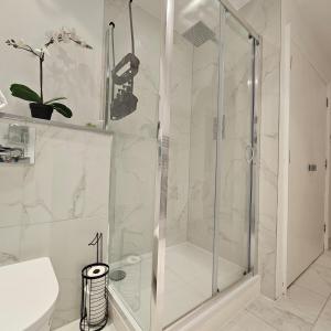a shower with a glass door in a bathroom at Central Suite and Private Patio! in London