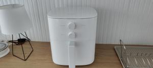 a white blender sitting on a table next to a lamp at Pine forest house 5 in Gauja