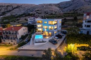 an aerial view of a large white house with a parking lot at Babic Apartments in Pag