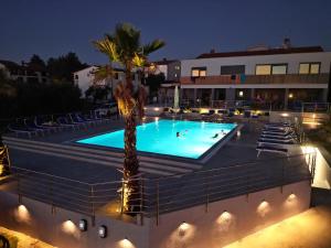 a swimming pool with a palm tree in front of a building at Viola Medulin in Medulin +20 photos