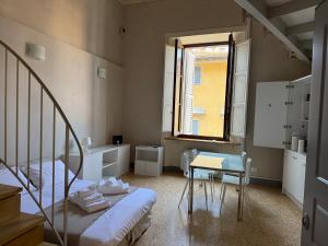 a room with a bed and a table and a window at Loft Termini in Siena