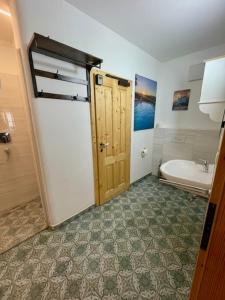 a bathroom with a door and a tub and a sink at Aurelia in Sulzbach-Rosenberg