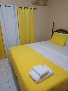 a bedroom with a yellow bed with towels on it at Embassy Royale in Kingston +18 photos