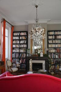 a living room with a red couch and a chandelier at la maison, chambre d'hôtes de charme et atelier d'artiste, Libourne saint Emilion in Libourne