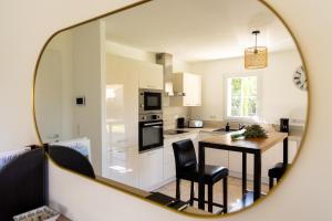 a kitchen with a table and chairs and a mirror at La Villa Sable en Provence in Saint-Saturnin-lès-Apt