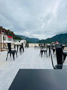 un grupo de mesas y sillas en un techo en Hop Inn Hostels Rishikesh, en Narendranagar