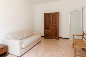 un soggiorno con divano bianco e mobile in legno di Xenia - 2rooms apt in Salita Sant'Agostino 15 a Rapallo