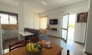 a living room with a table with a basket of fruit at Coastal Comfort 110 in Perivólia