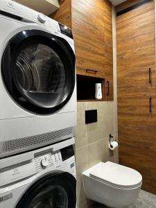 a washing machine and a toilet in a bathroom at Verde Klon Apartment- Lotnisko Jasionka in Jasionka +27 photos