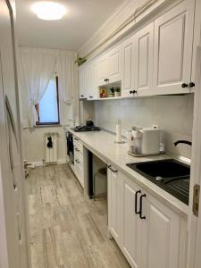 a kitchen with white cabinets and a counter top at Central and beautiful flat in Focşani +15 photos