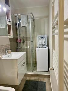 a bathroom with a shower and a white refrigerator at Central and beautiful flat in Focşani +12 photos