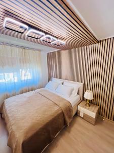 a bedroom with a large bed and a window at Imperium DK Apartament in Giurgiu