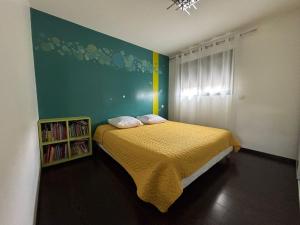 une chambre avec un lit avec un couvre-lit jaune dans l'établissement Maison villa avec piscine, à Sadirac 18 autres photos