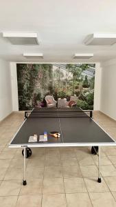 a ping pong table in the middle of a room at Villa Les Rosiers private parking in Le Touquet-Paris-Plage