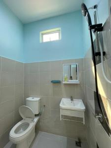 a bathroom with a toilet and a sink at Rembun Homestay, Besut in Kampong Tok Pakir +10 photos