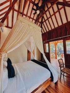 ein Schlafzimmer mit einem Bett mit Moskitonetz in der Unterkunft mata villas gili trawangan in Gili Trawangan