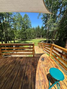 a wooden deck with a bench and a table at Căsuța din poiană in Dorna Cîndrenilor +5 photos