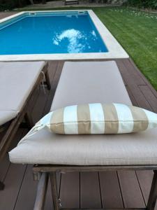 a pillow sitting on a bench next to a swimming pool at Casa das Ribeiras in Azoia de Baixo